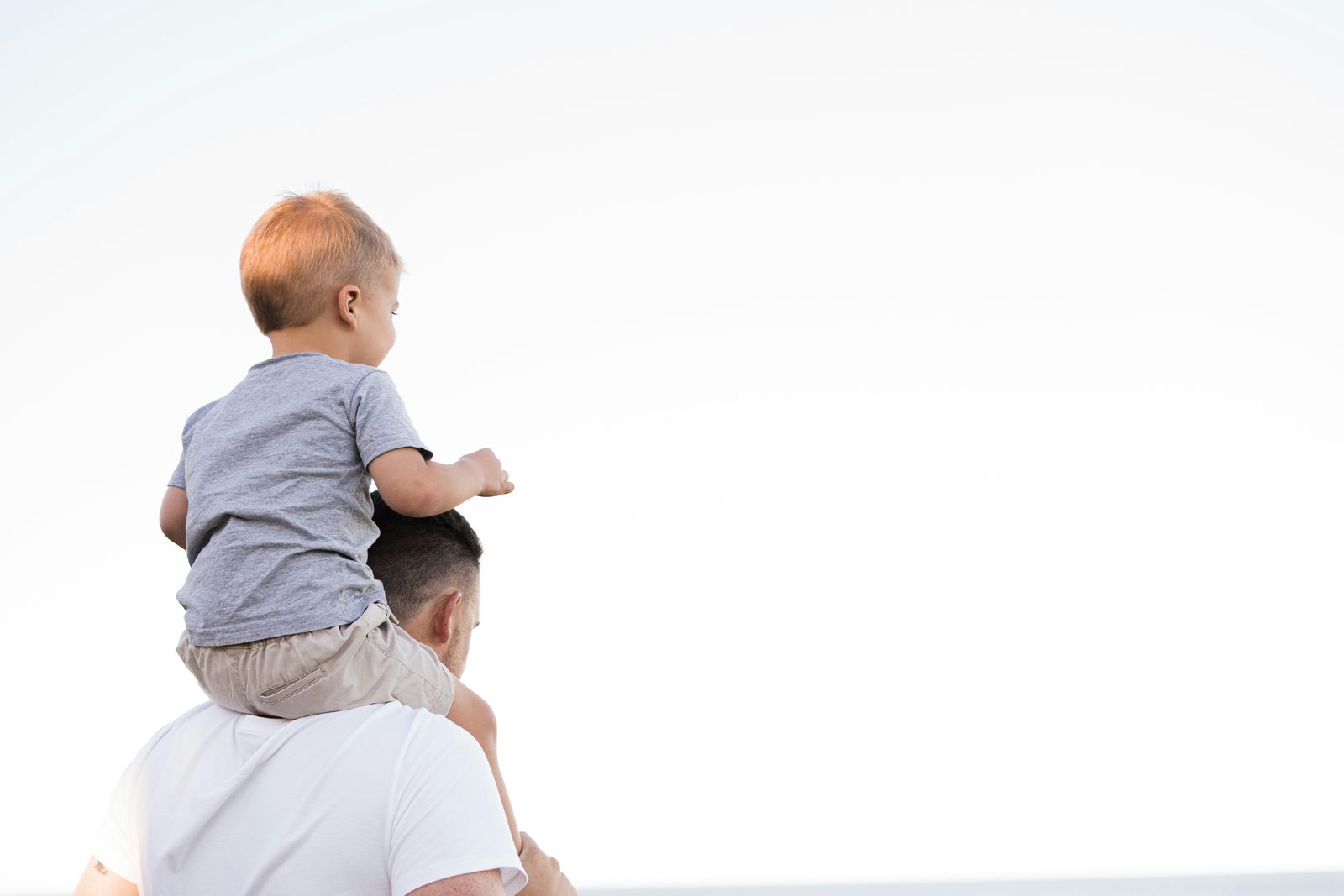 A father playing with his young son, representing the identity shift of new fatherhood, men's therapy in Ontario
