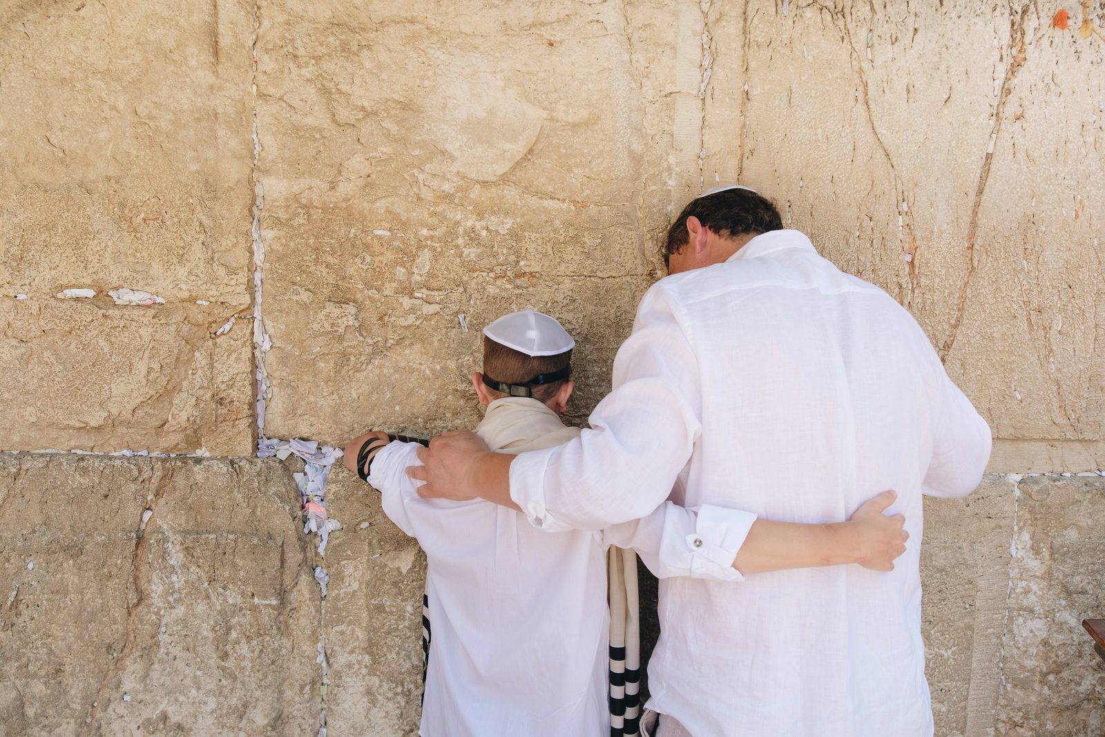 A father and son at the Western Wall in Jerusalem, representing meaning, identity, and intergenerational connection in Jewish men's therapy.