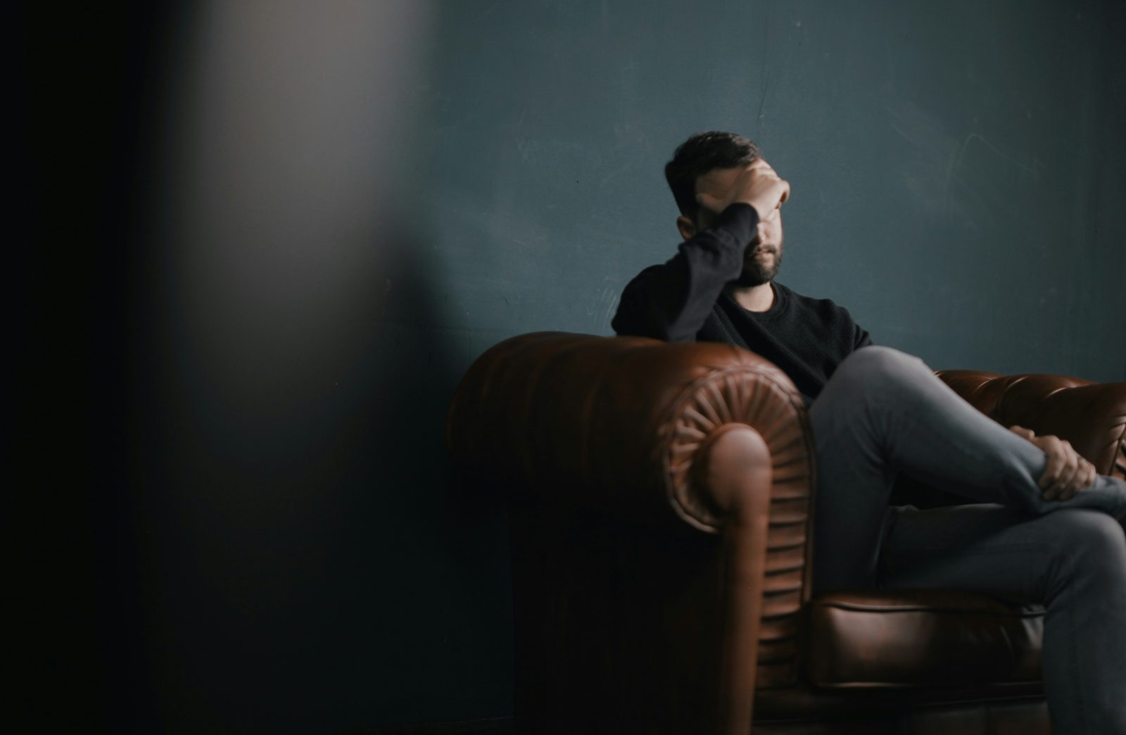 A man looking tense and preoccupied, unable to settle
